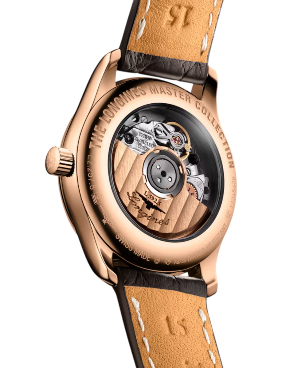 Rose-gold Longines Master Collection watch shown from the back, with a transparent case back revealing the mechanical movement and rotor, tan stitched leather strap