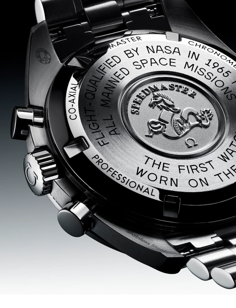 Close-up of a stainless steel watch back with Omega logo and 'Speedmaster' engravings.