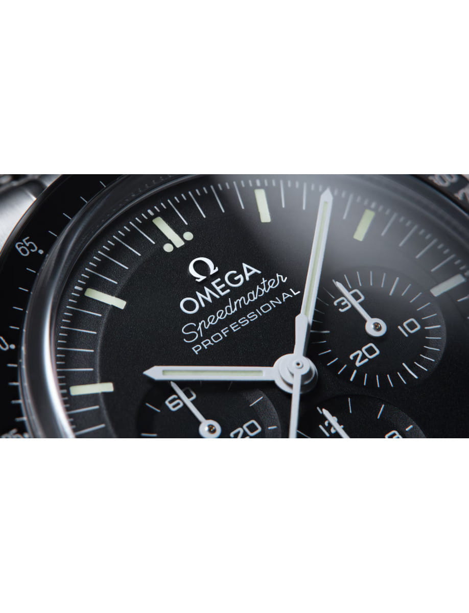Close-up of an Omega Speedmaster Professional chronograph dial with white hands and subdials.
