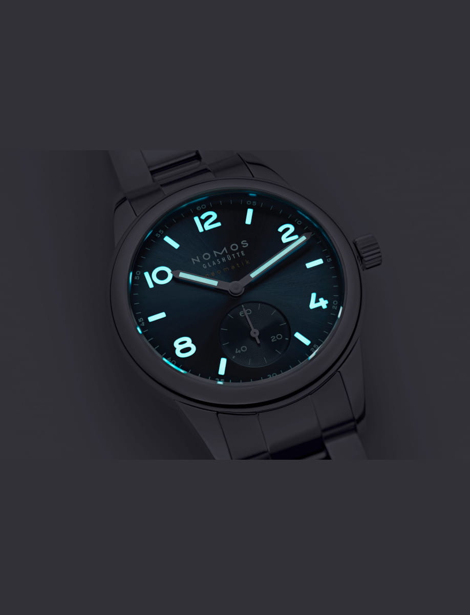 NOMOS Glashütte wristwatch with stainless steel case and bracelet, and polar blue dial with luminous hands and hour numerals.