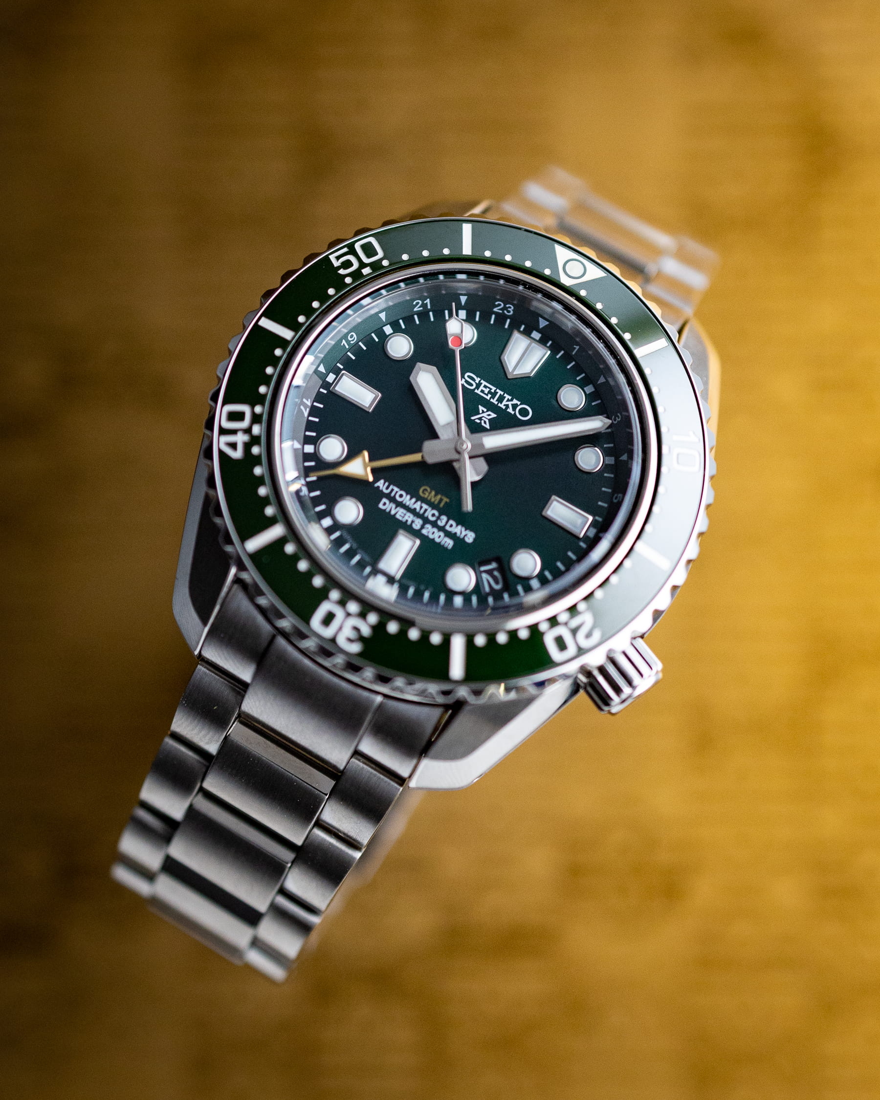 Seiko wristwatch with stainless steel case and bracelet, and green dial.