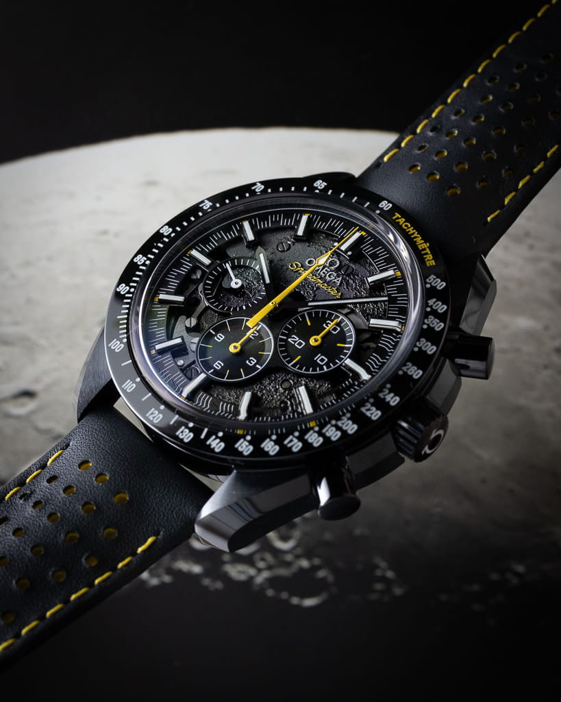 Omega wristwatch with black ceramic case, black dial, and black rubber strap.