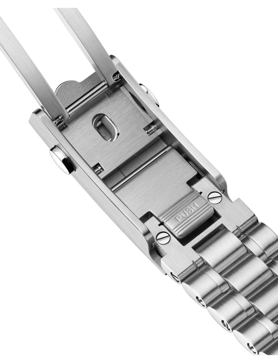 Close-up of a stainless steel deployment clasp on a metal watch band, with a visible 'PUSH' tab for release