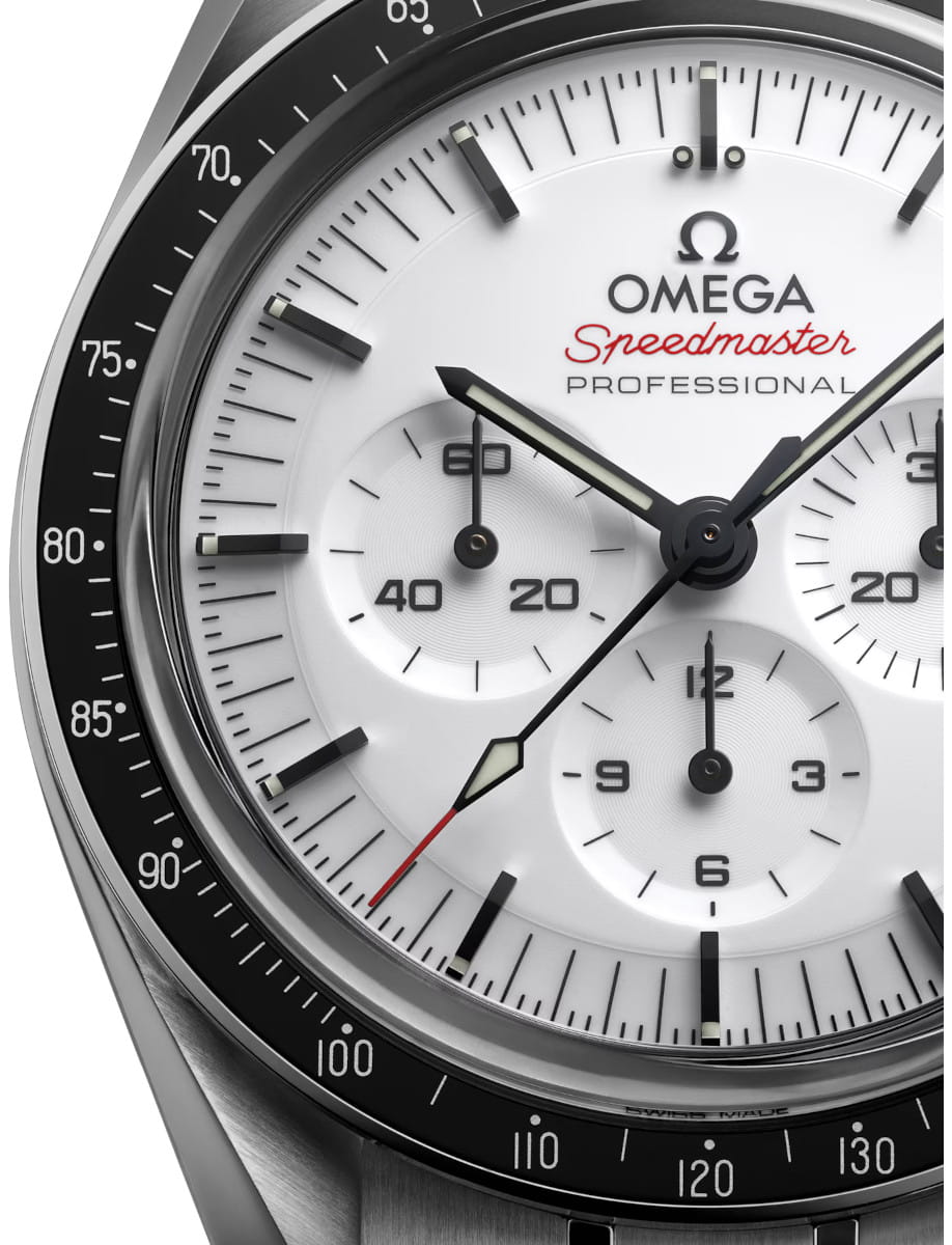 Close-up of an Omega Speedmaster Professional watch face with white dial and black tachymeter bezel.