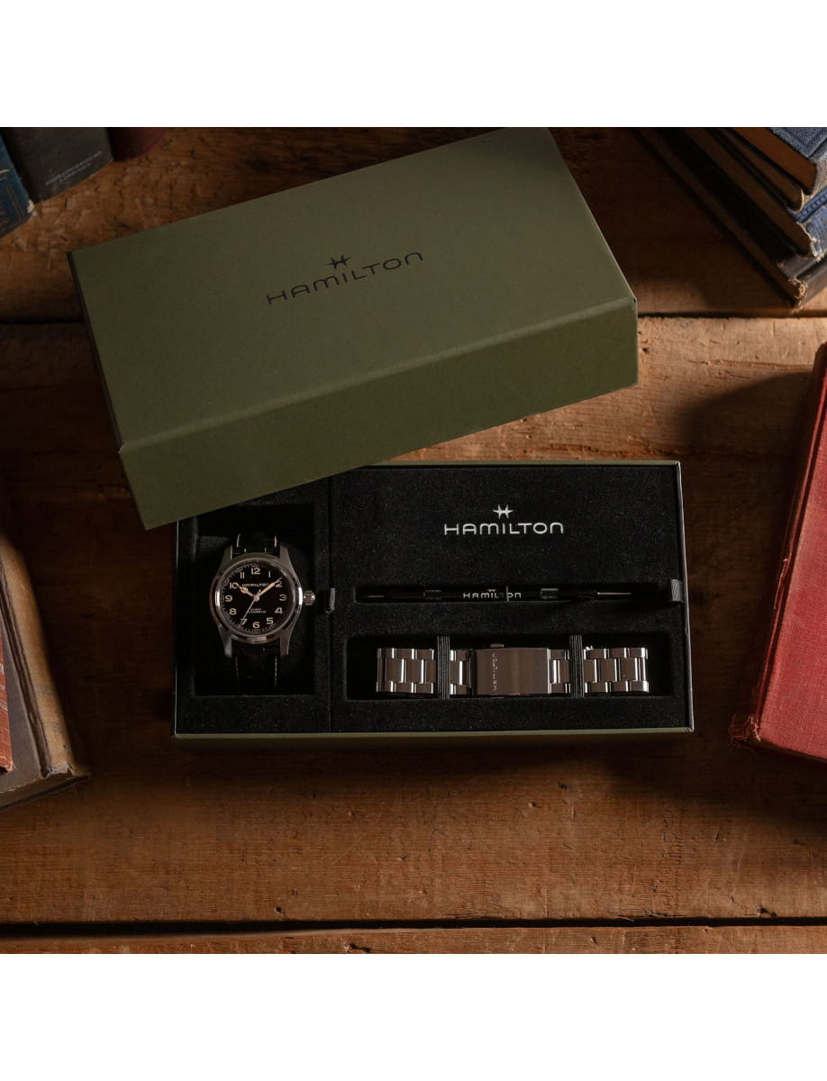 Box view of Hamilton wristwatch with stainless steel case, black dial, and black leather strap, and additional stainless steel bracelet.