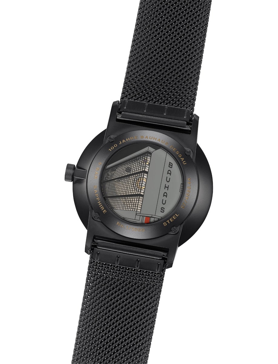 Junghans wristwatch with PVD coated case and bracelet, and mineral crystal case back with partially transparent Bauhaus motif.