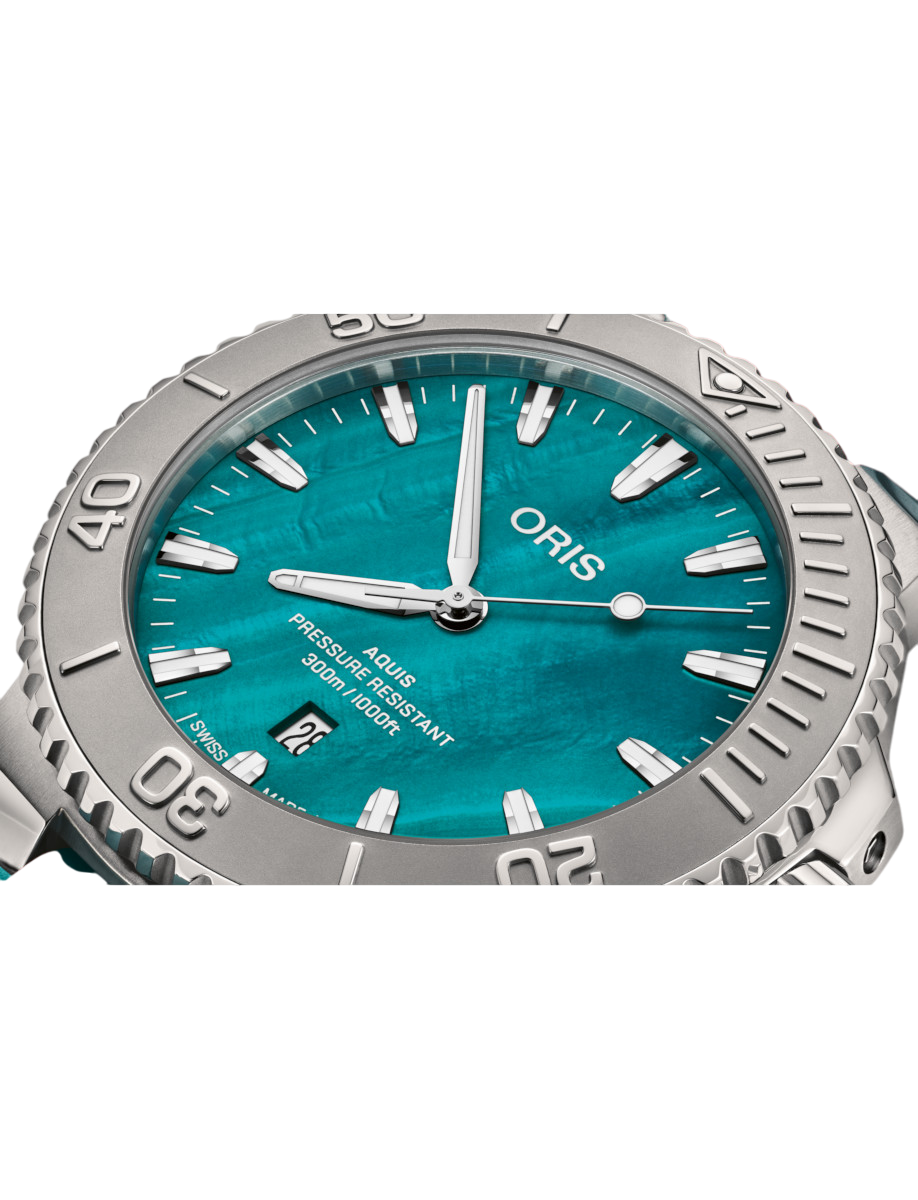 Close view of Oris dial with stainless steel case,an aqua green mother-of-pearl dial, and aqua green rubber strap.