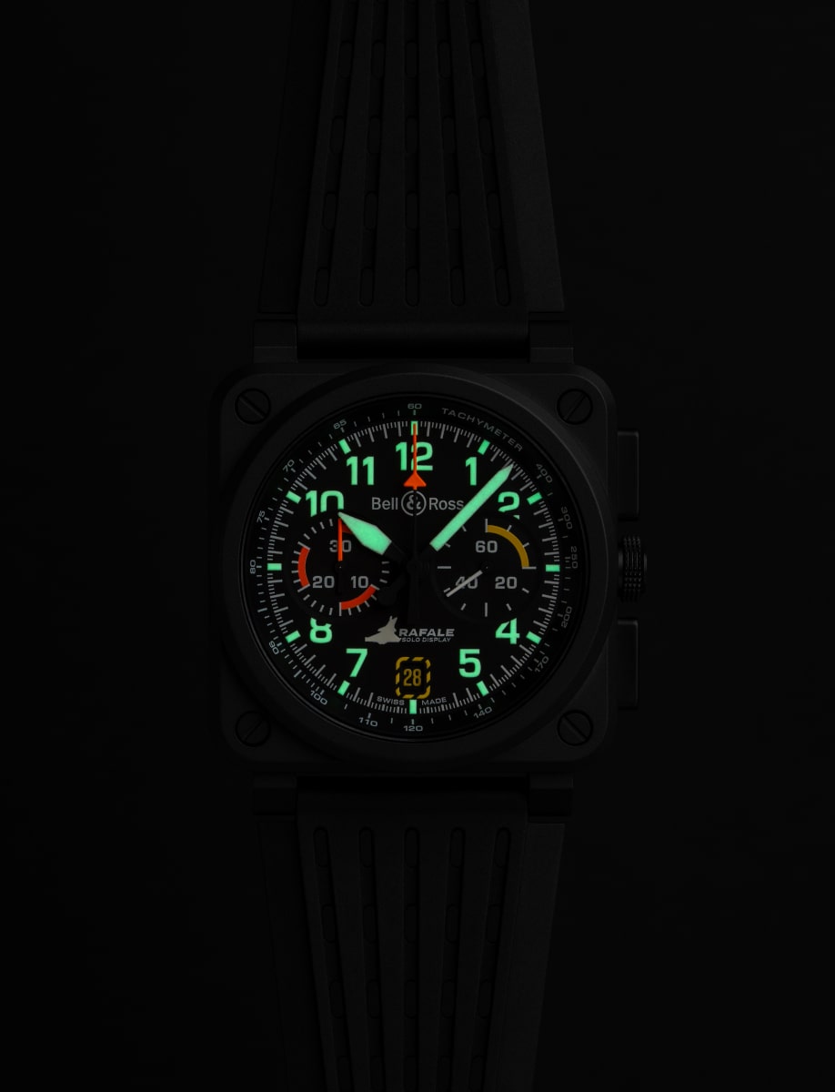 Night view of Bell&Ross wristwatch with micro-blasted black ceramic case, black openworked rubber and ultra-resilient black synthetic fabric with Rafale Solo Display logo marking, and luminous hands and hour markers.