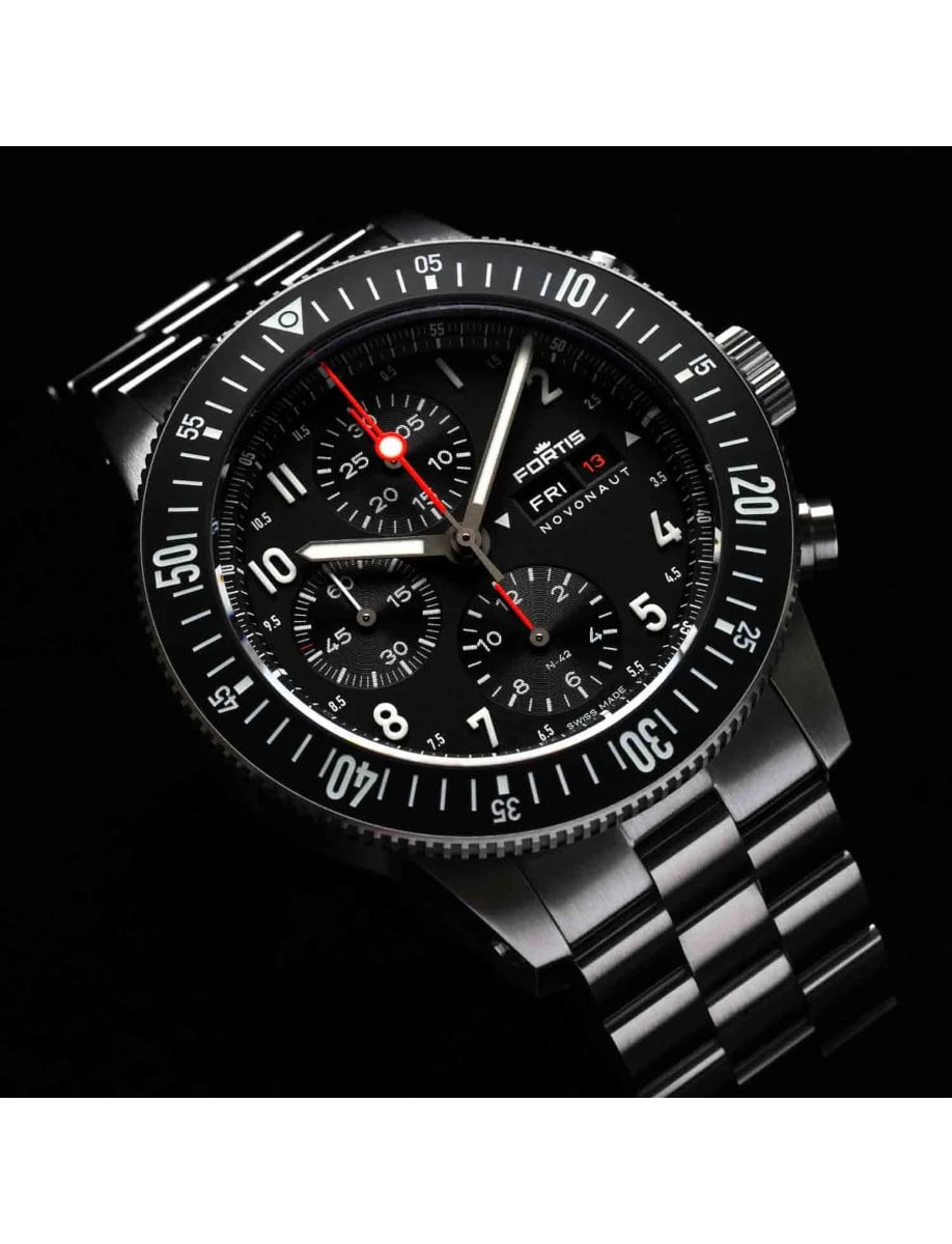 Front side view of a wristwatch with a recycled stainless steel case and bracelet, and a matte black dial.