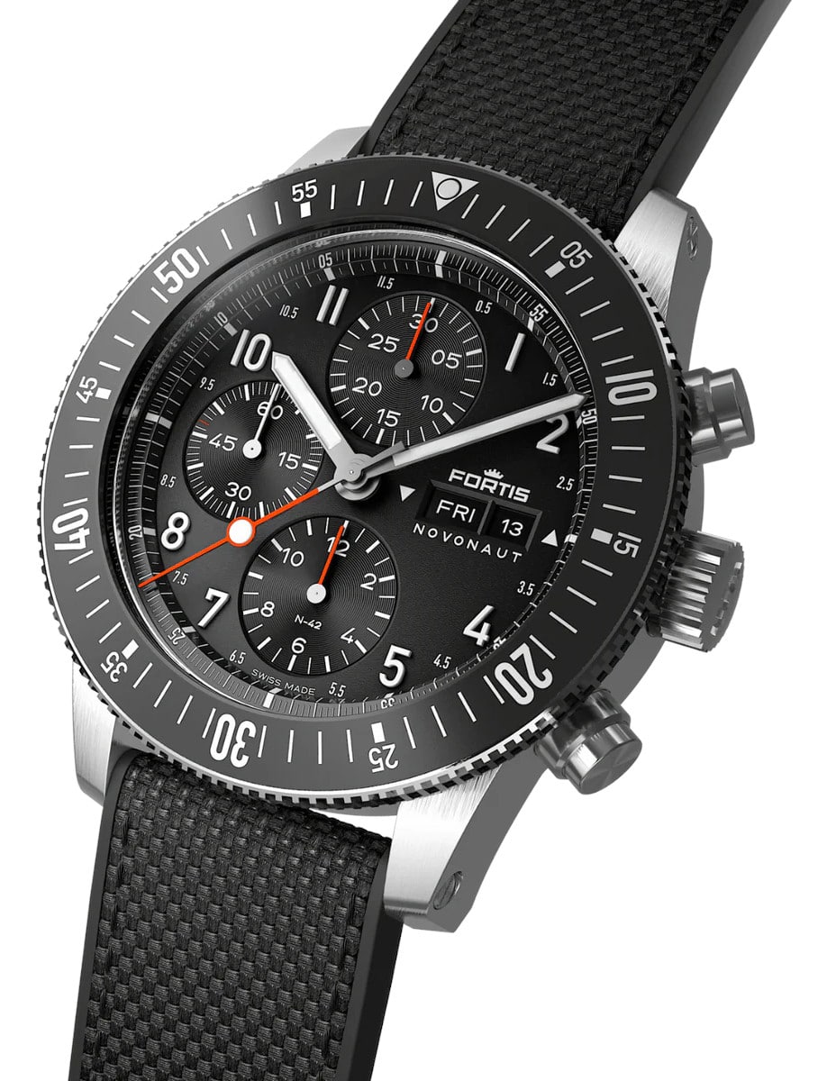 Side view of a wristwatch with a recycled stainless steel case, a matte black dial, and a hybrid rubber/textile fabric strap.