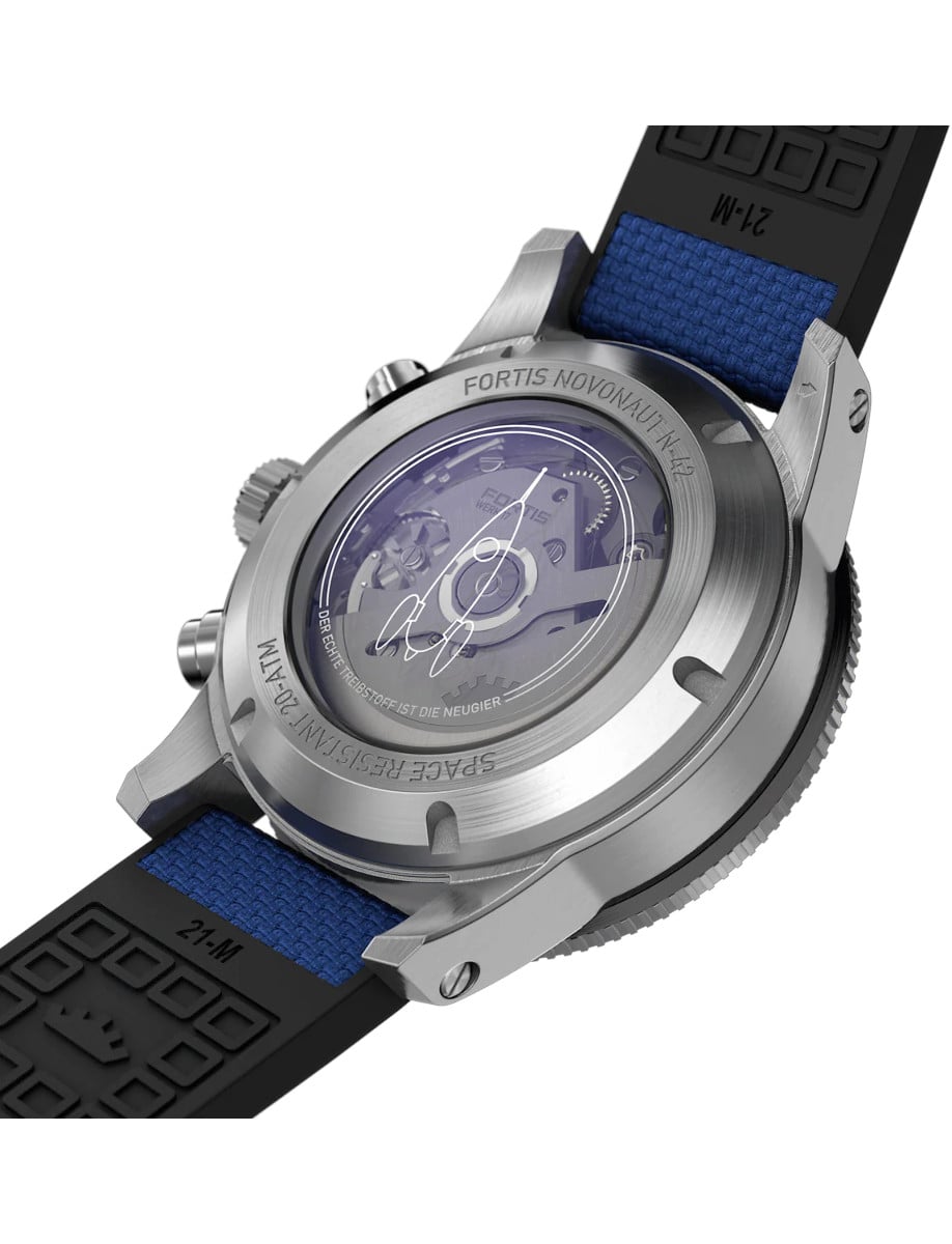 Case back of a wristwatch with a recycled stainless steel case and a hybrid textile strap, showing the automatic movement.