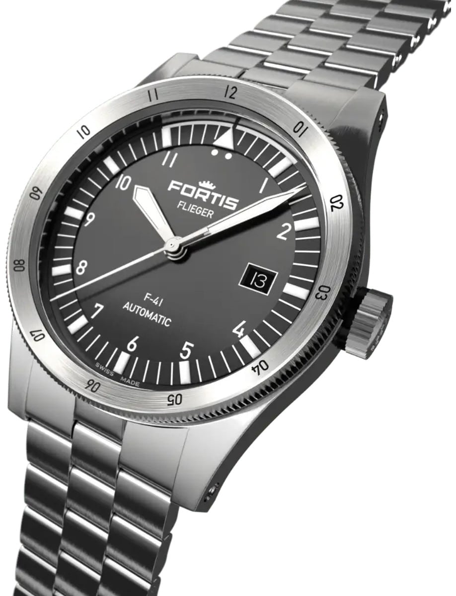 Side front view of a wristwatch with a recycled stainless steel case, a vertically brushed black dial, and a recycled stainless steel bracelet.