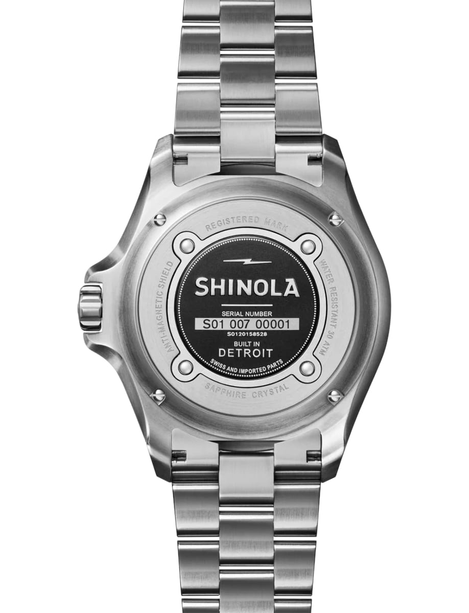 Back view of Shinola wristwatch with stainless steel case and bracelet and red dial
