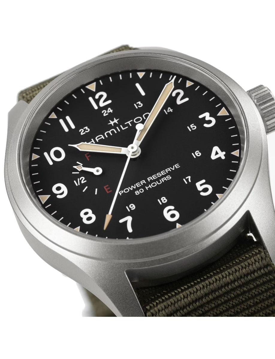 Close view of black dial of Hamilton wristwatch with stainless steel case and rugged khaki green NATO strap.