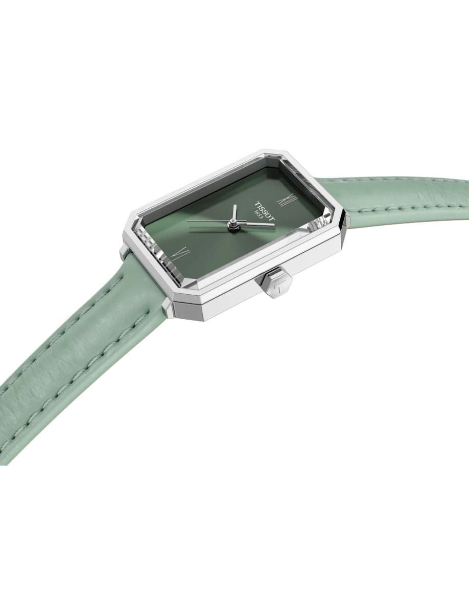 Side view of Tissot wristwatch with stainless steel case, green dial, and green synthetic strap.