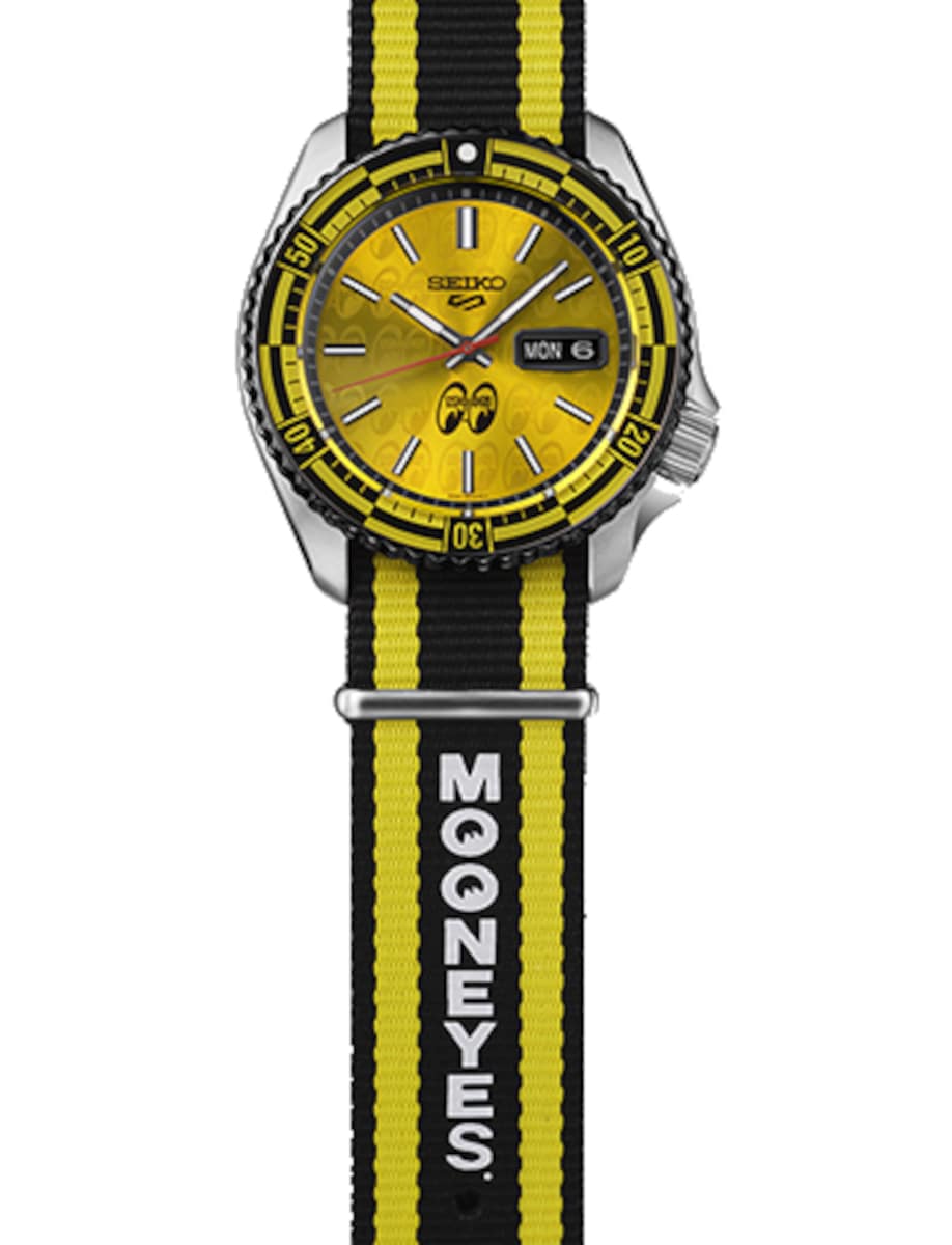 Seiko wristwatch with stainless steel case and additional yellow and black striped nylon strap, and yellow dial.