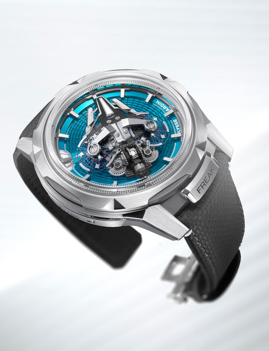Side view of Ulysse Nardin wristwatch with titanium case, blue turquoise enamel discs on dial, and black rubber strap.