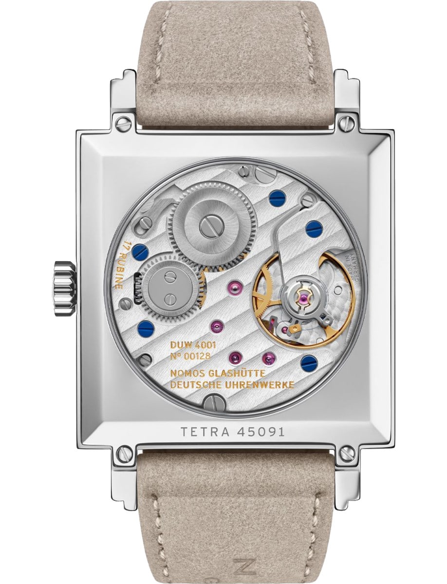 Side view of Nomos wristwatch with stainless steel case, sapphire crystal case back, and vegan velour remborde beige strap.