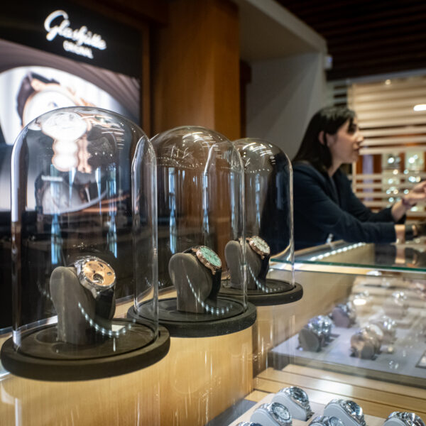 Several watches under bell jars from Glashutte Original on the counter at Feldmar's World Watch Day event