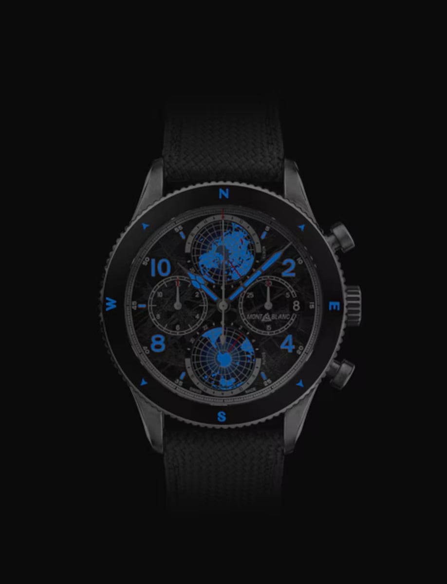 Night view of Montblanc wristwatch with titanium case, dark grey dial with luminescent, and dark grey strap.