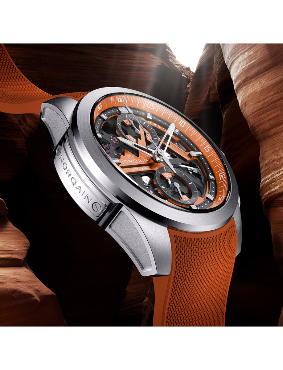Side view of Norqain wristwatch with stainless steel case, skeleton orange dial, and orange rubber strap.