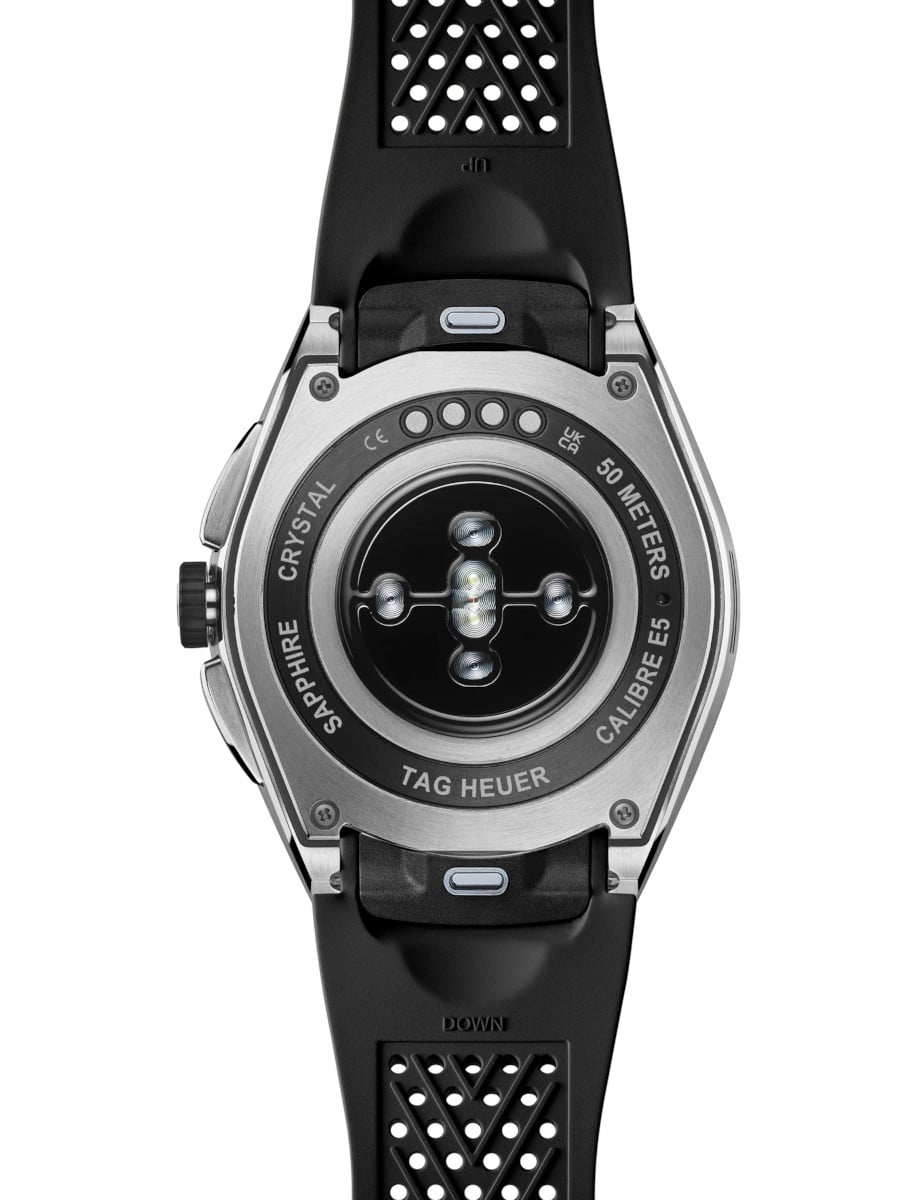 Back view of Tag Heuer wristwatch with stainless steel case, OLED display, and black rubber strap.
