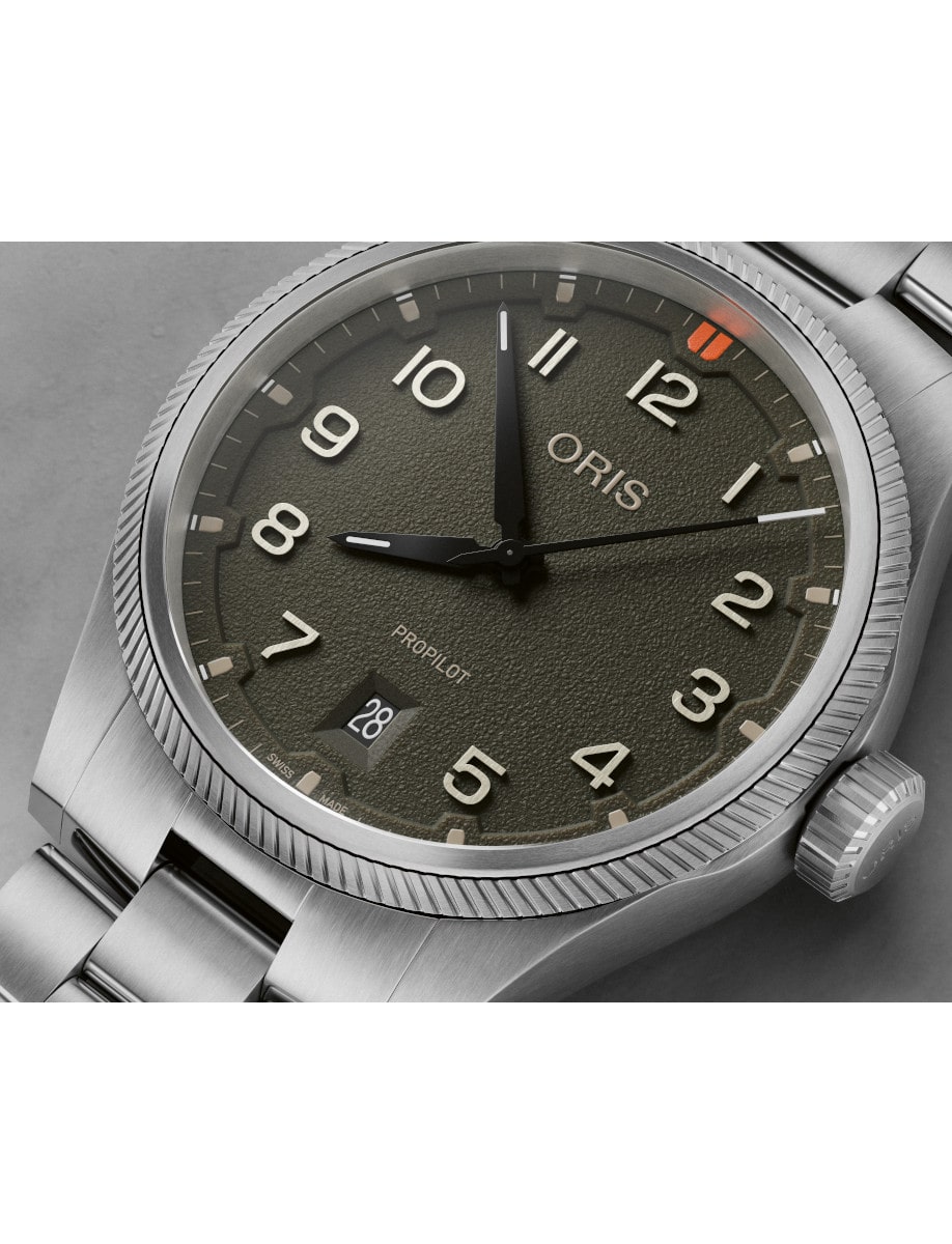Close view of Oris wristwatch with stainless steel case and bracelet, and moss green dial.