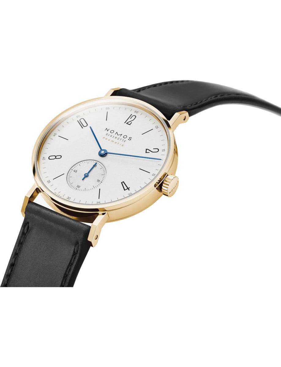 Side view of Nomos wristwatch with gold 18k 3N case, white silver-plated dial, and black Horween Genuine Shell Cordovan