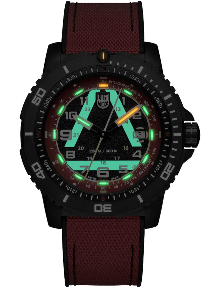 Night view of Luminox wristwatch with CARBONOX case, red and black dial, and red rubber strap.