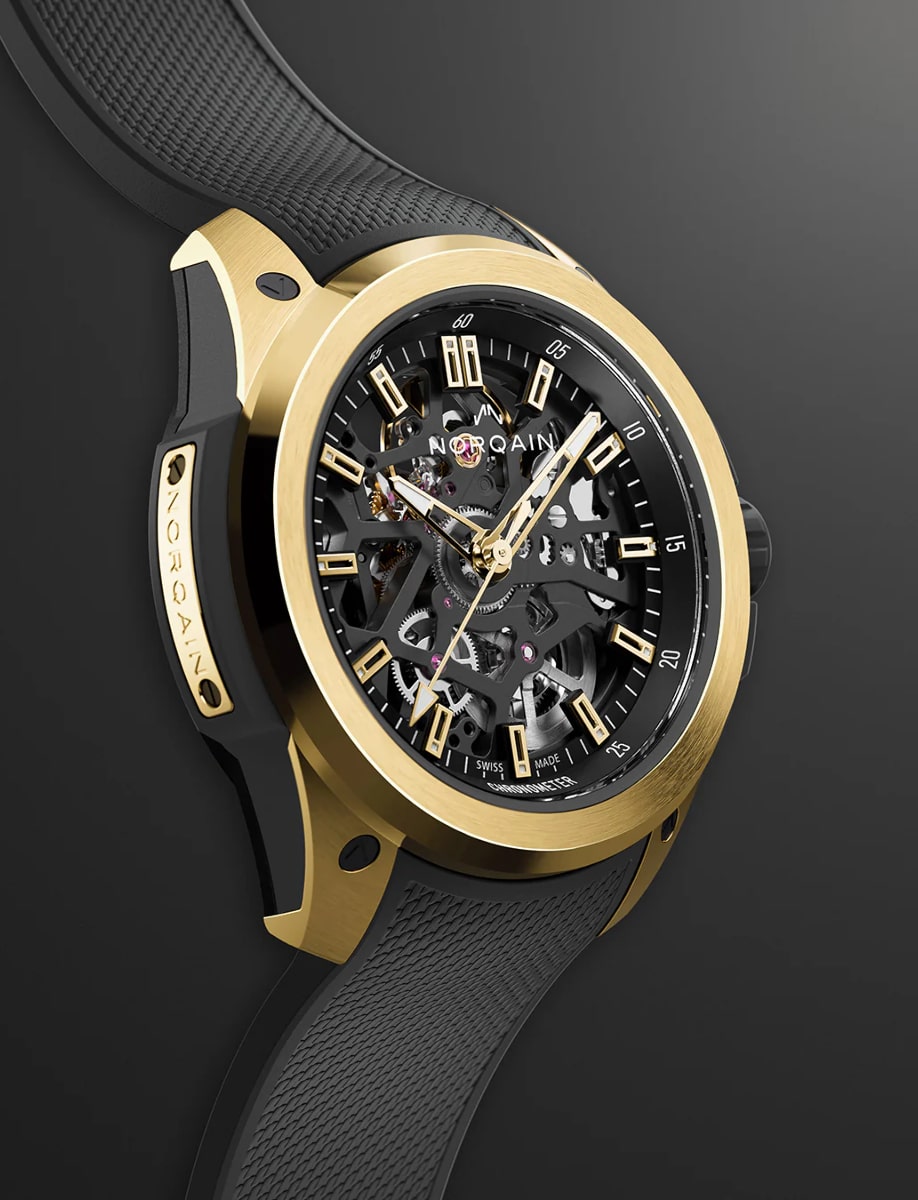 Right side view of Norqain wristwatch with yellow gold case, openworked black dial and black rubber strap