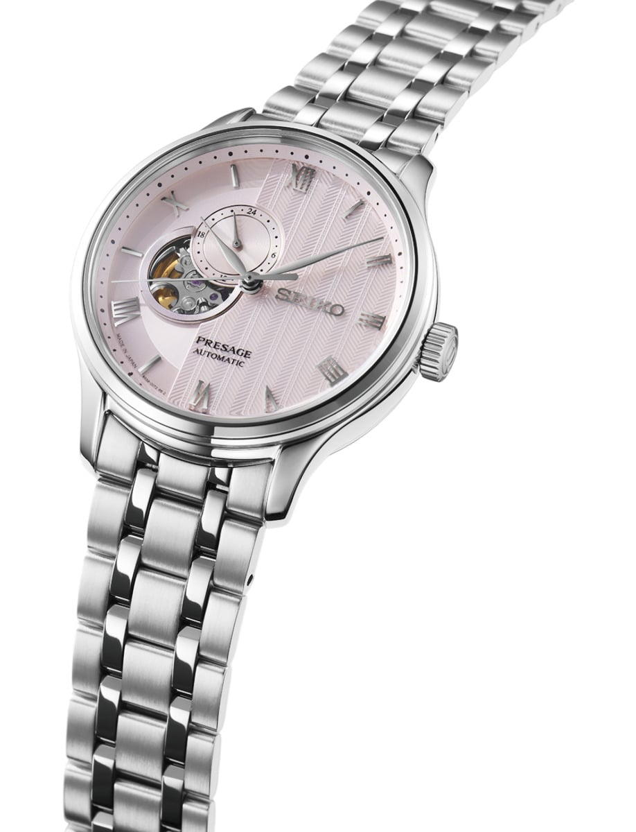 Side view of Seiko wristwatch with stainless steel case and bracelet and pink beige dial