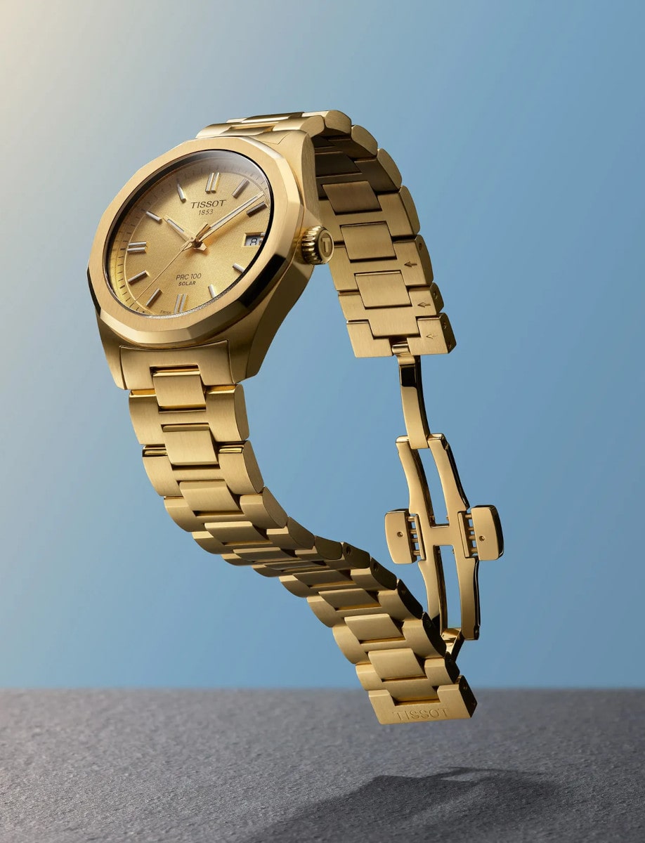 Side view of Tissot wristwatch with 316L stainless steel case and bracelet with yellow gold PVD coating, and champagne dial.