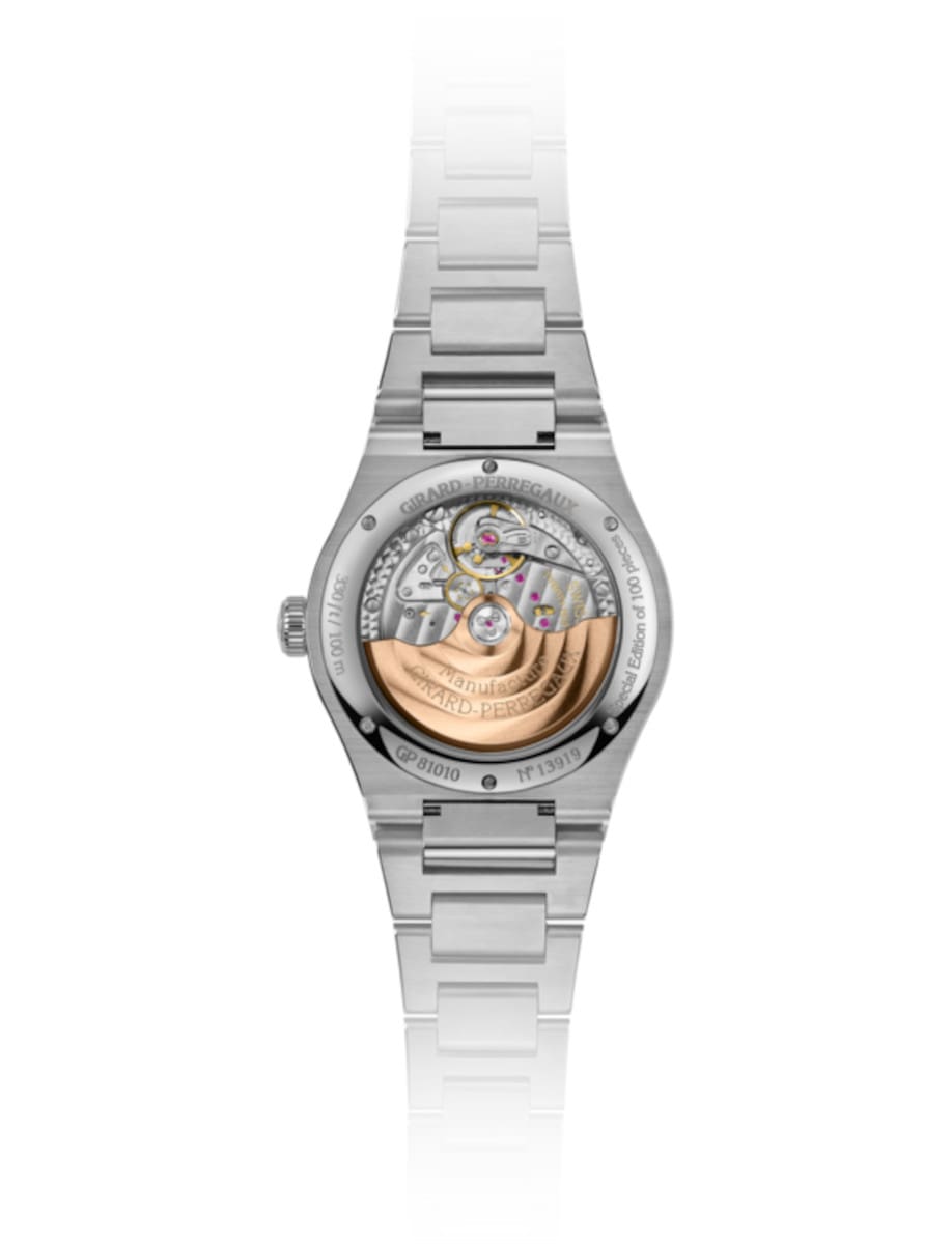 Night view of Girard-Perregaux wristwatch with stainless steel case and bracelet, open case back.