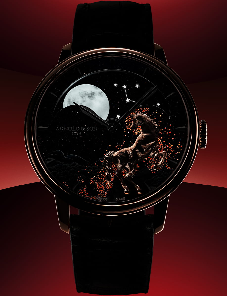 Night view of Arnold&Son wristwatch with 18k red gold case, black aventurine dial, and black leather strap.