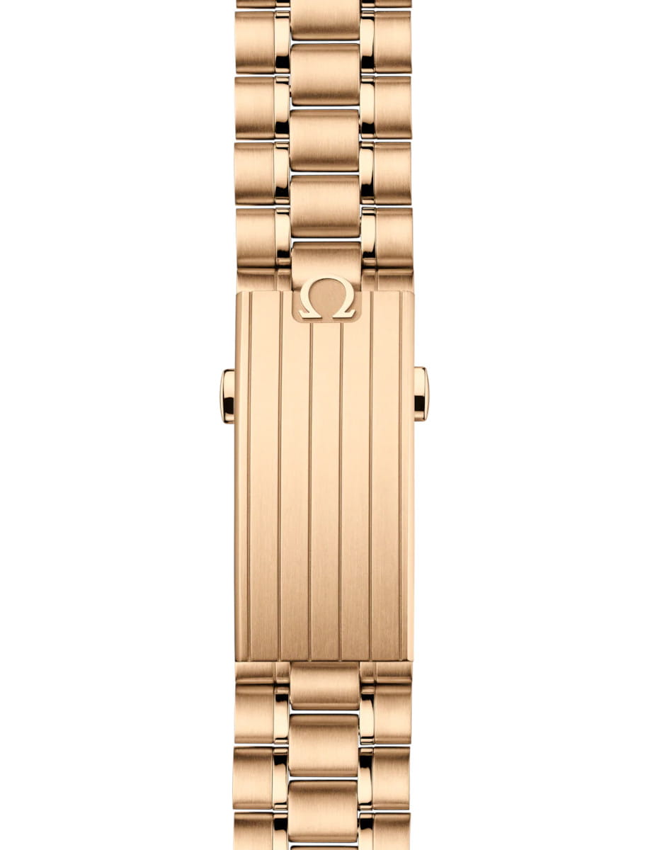 Gold Omega watch bracelet clasp with grooved vertical panels and logo symbol nearby.