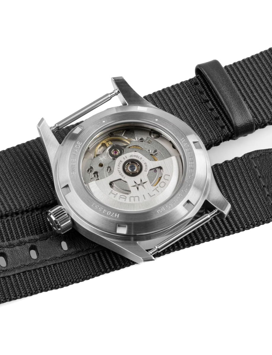 Back view of Hamilton Khaki Field wristwatch with stainless steel case, green dial, and black textile strap.