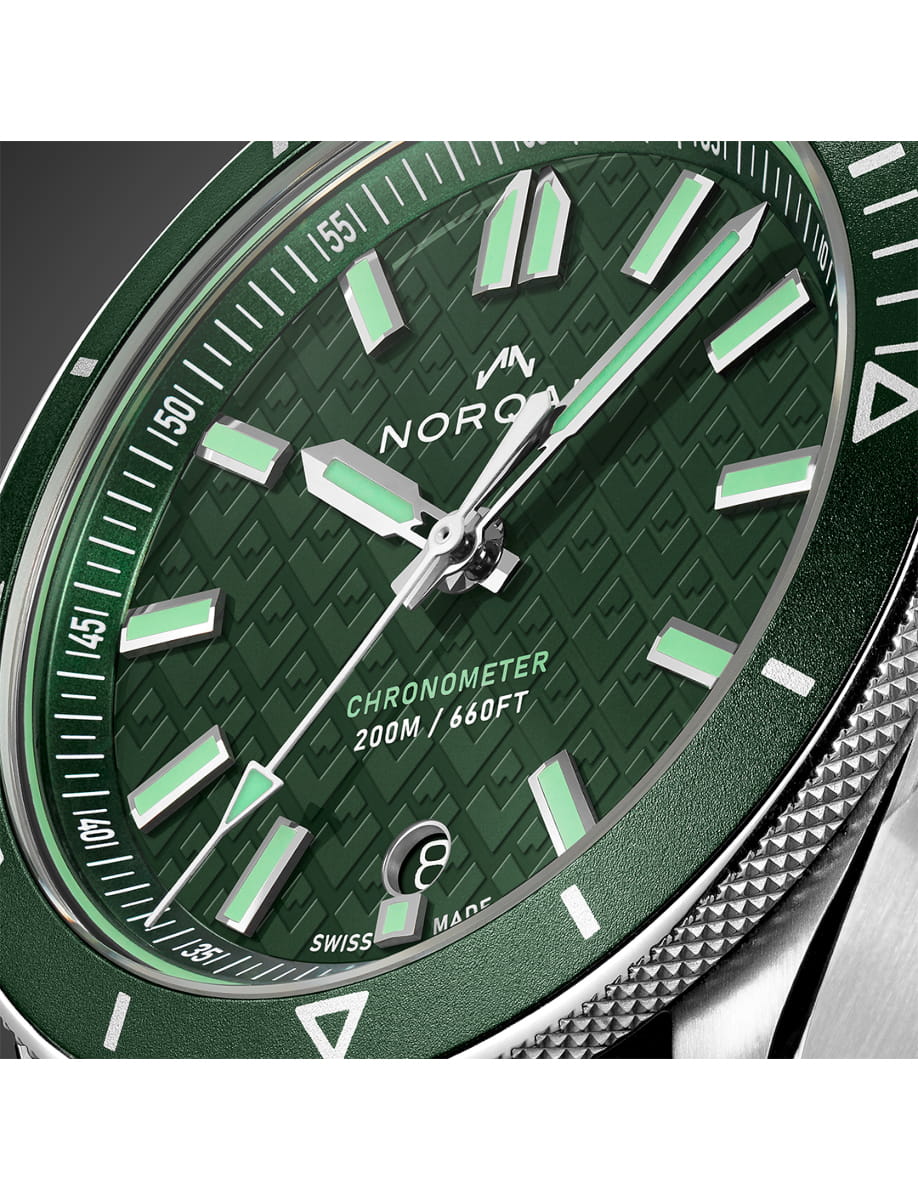 Closer view of Norqain wristwatch with stainless steel case and bracelet and green dial