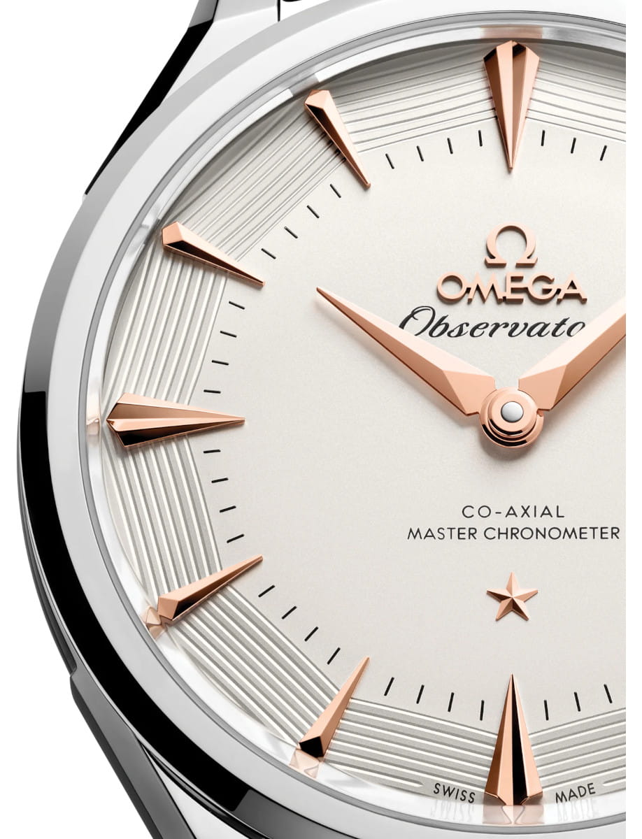 Close view of Omega Constellation Observatory wristwatch with O‑MEGASTEEL case, open case back, and grey alligator leather.