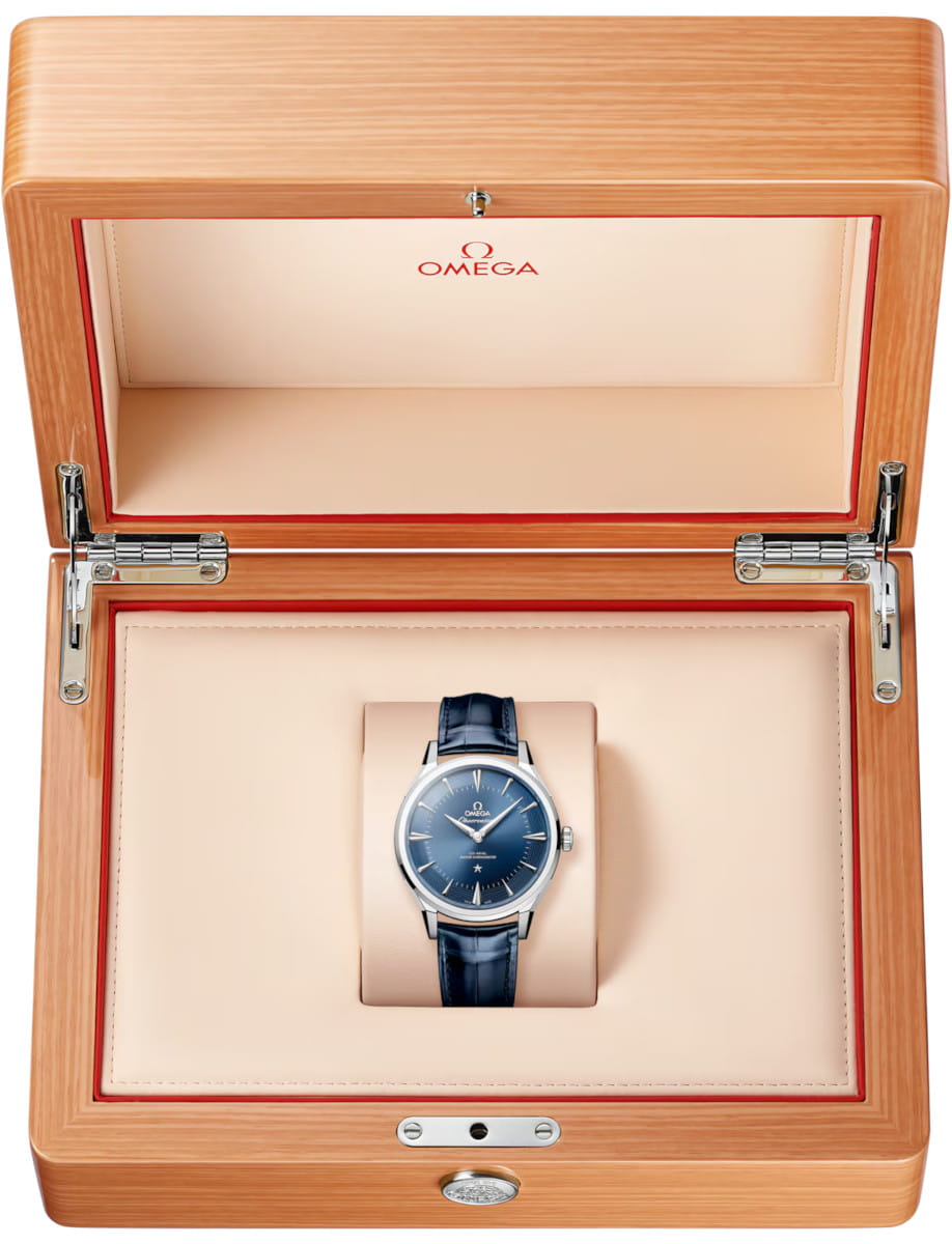 Box view of Omega Constellation Observatory wristwatch with O‑MEGASTEEL case, blue dial, and blue alligator leather.