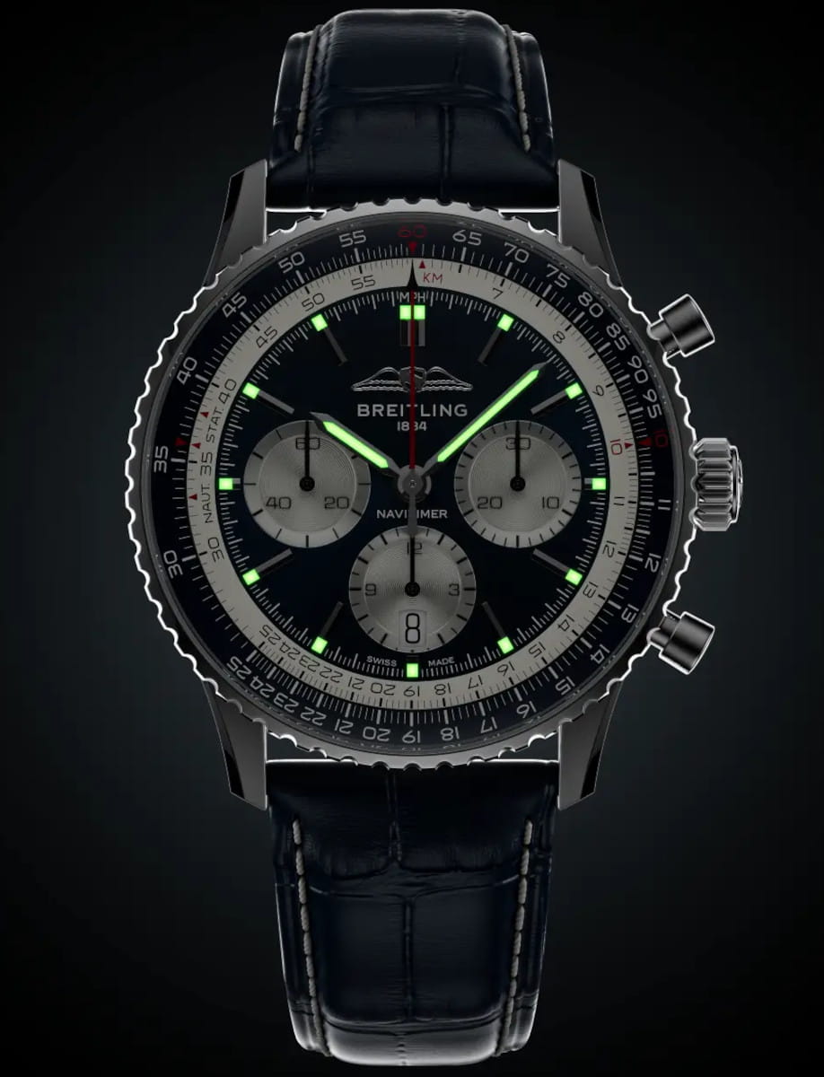 Night view of Breitling Navitimer wristwatch with stainless steel case, blue dial, and blue alligator leather strap.