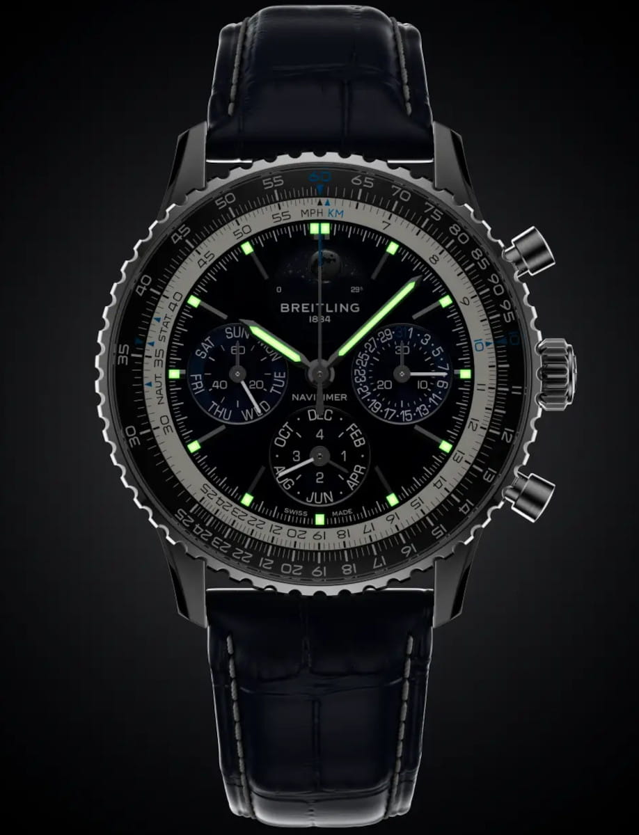 Night view of Breitling wristwatch with platinum case, deep blue dial with luminous hands and markers, and blue alligator leather.