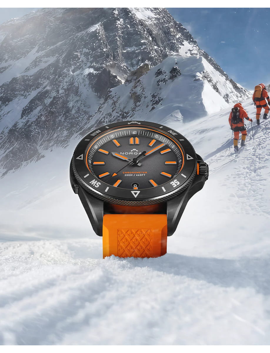 Front view of Norqain wristwatch with stainless steel case, black dial and orange rubber strap