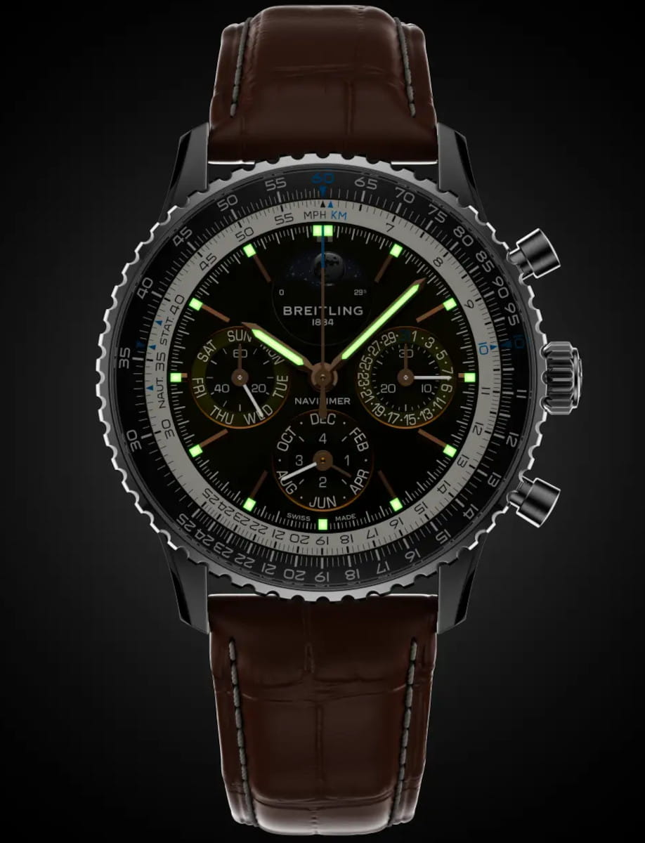Night view of Breitling Navitimer wristwatch with stainless steel and platinum case, anthracite dial, brown alligator leather strap.