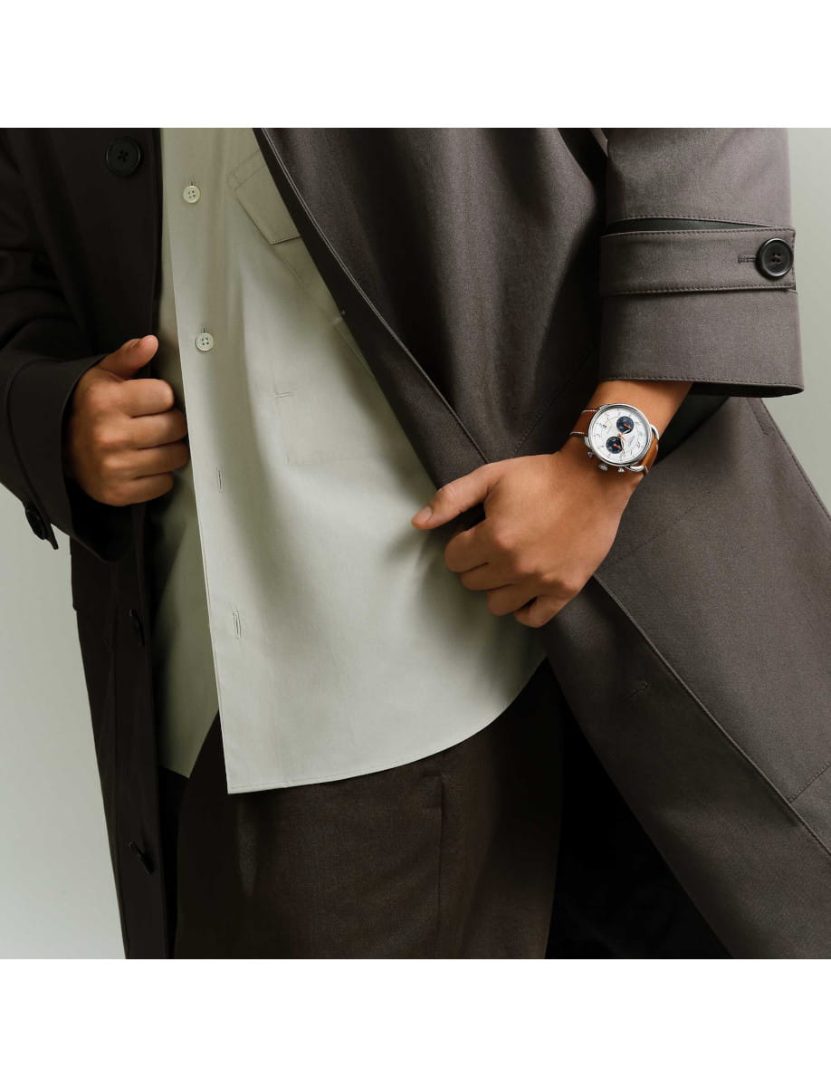 Lifestyle view of Hermes Arceau Chronographe wristwatch with stainless steel case, white silvered dial, natural Barenia calfskin strap.