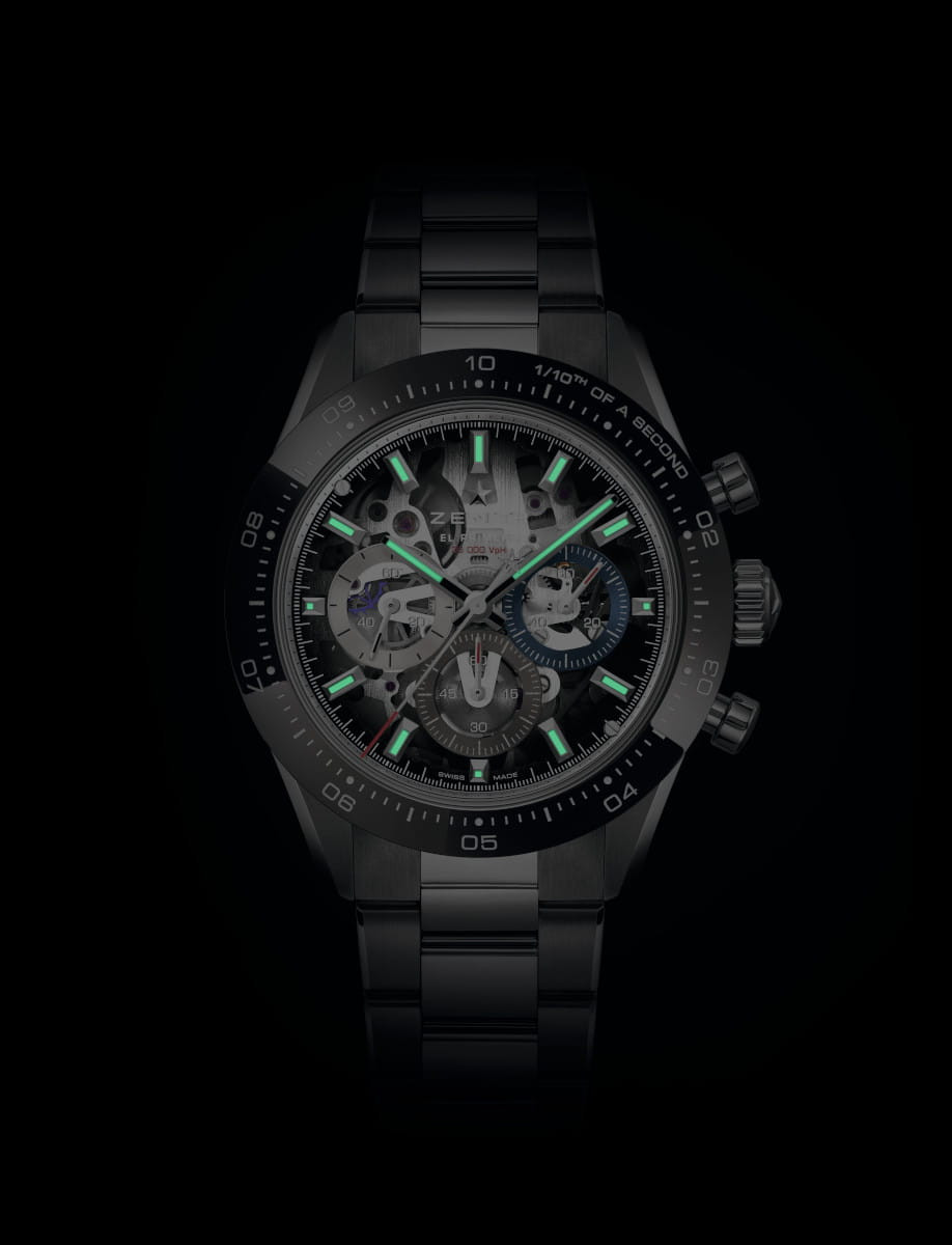 Night view of Zenith Chronomaster Sport Skeleton wristwatch with stainless steel case with black ceramic bezel, openworked dial with tinted sapphire with three different-coloured counters, and stainless steel bracelet.