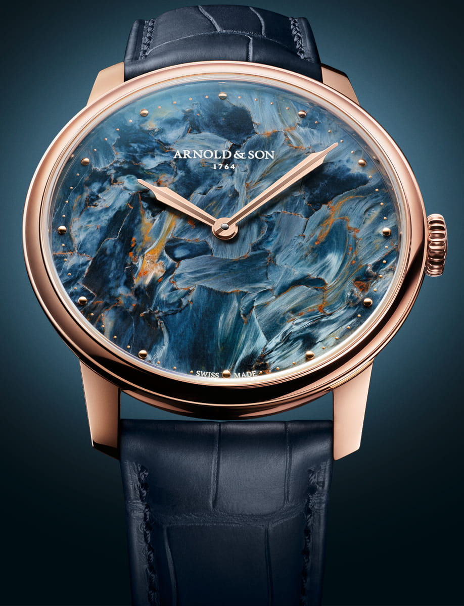 Front view of Arnold&Son HM Pietersite wristwatch with 18k red gold case, Namibian pietersite dial, and ink blue alligator leather strap.