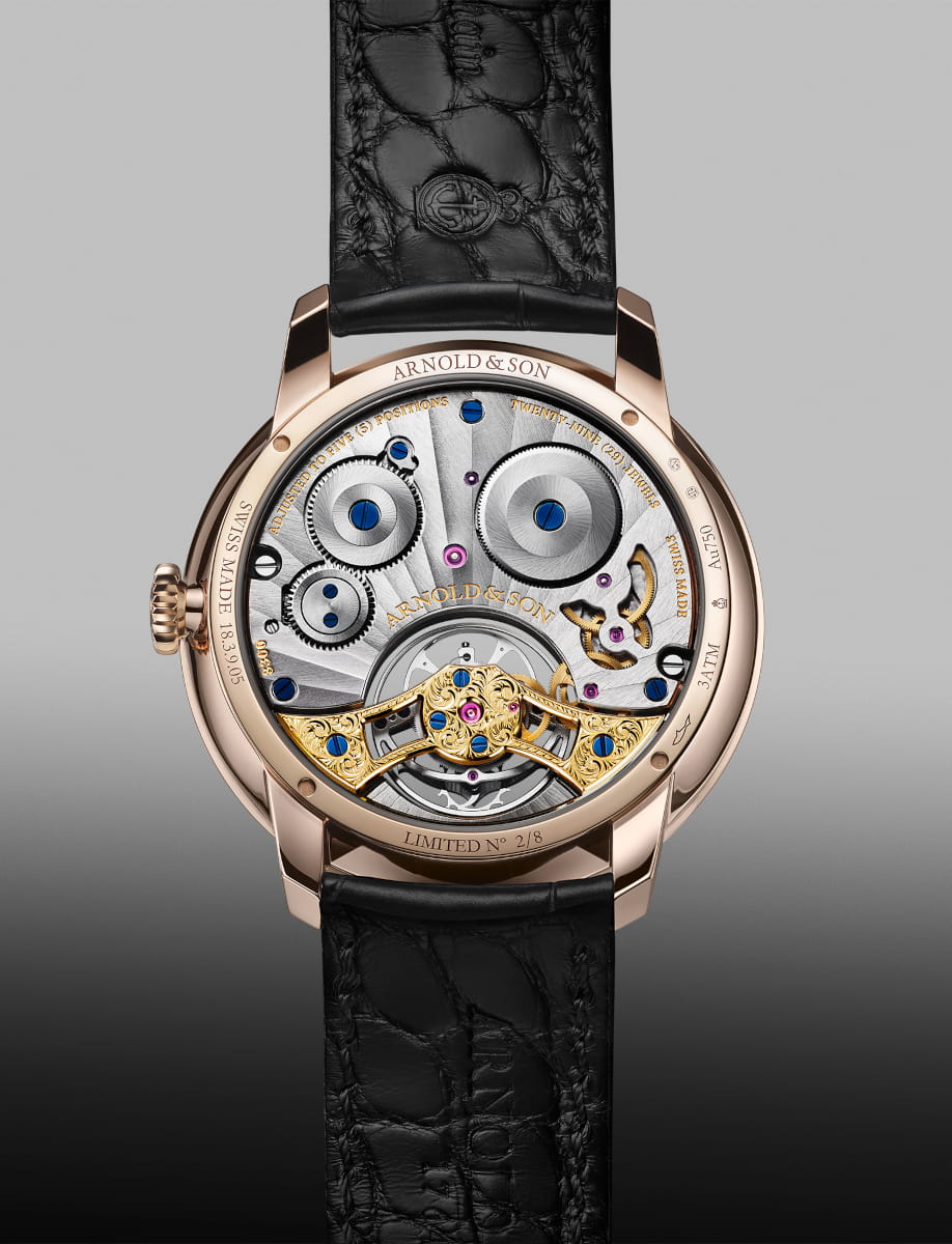 Back view of Arnold&Son wristwatch with 5n red gold case, black dial, and black leather strap.