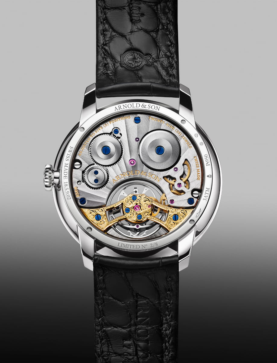 Back view of Arnold&Son wristwatch with platinum case, black dial, and black leather strap.