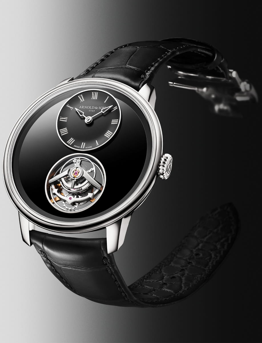 Side view of Arnold&Son wristwatch with platinum case, black dial, and black leather strap.