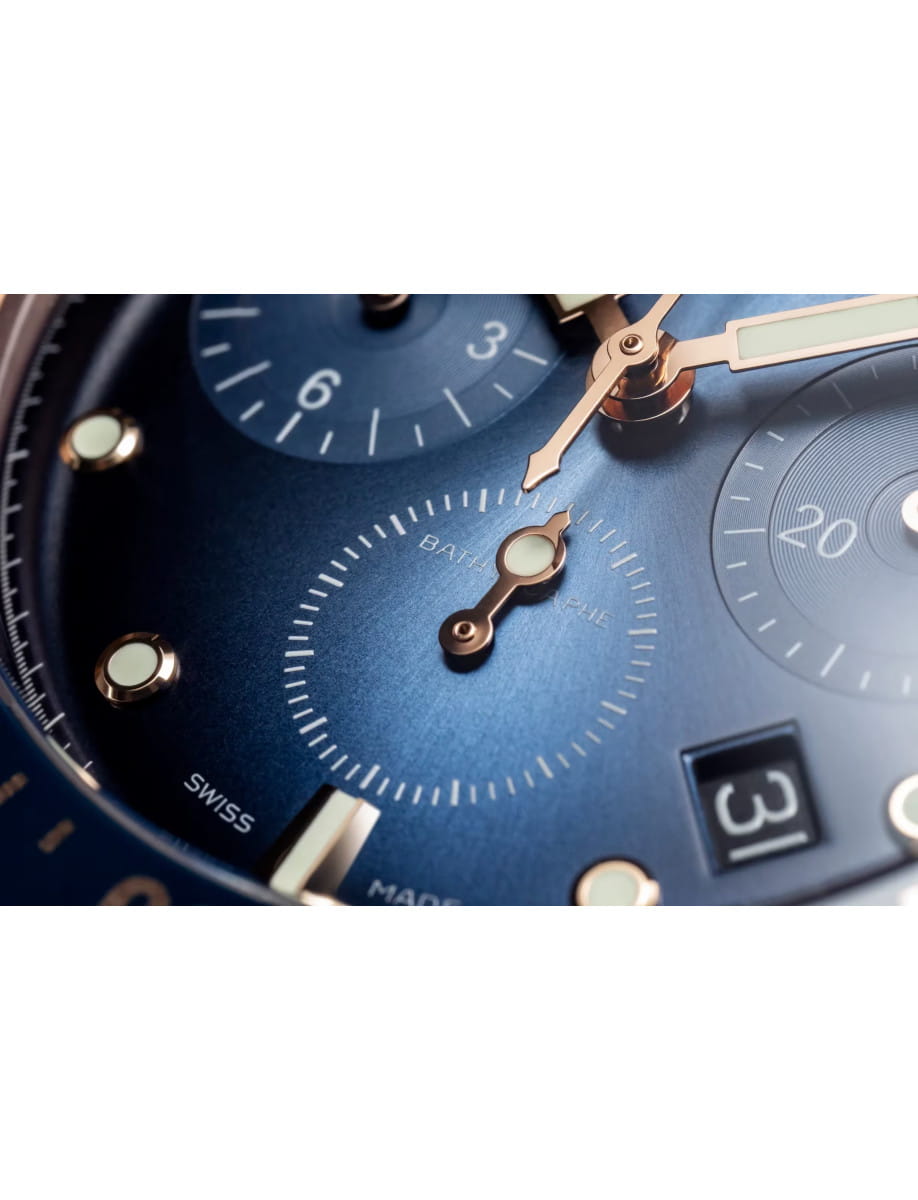 Close view of Blancpain Bathyscaphe Chronographe Flyback wristwatch with red gold case, sunburst blue with subtly graduated coloring dial, and blue sail-canvas strap.